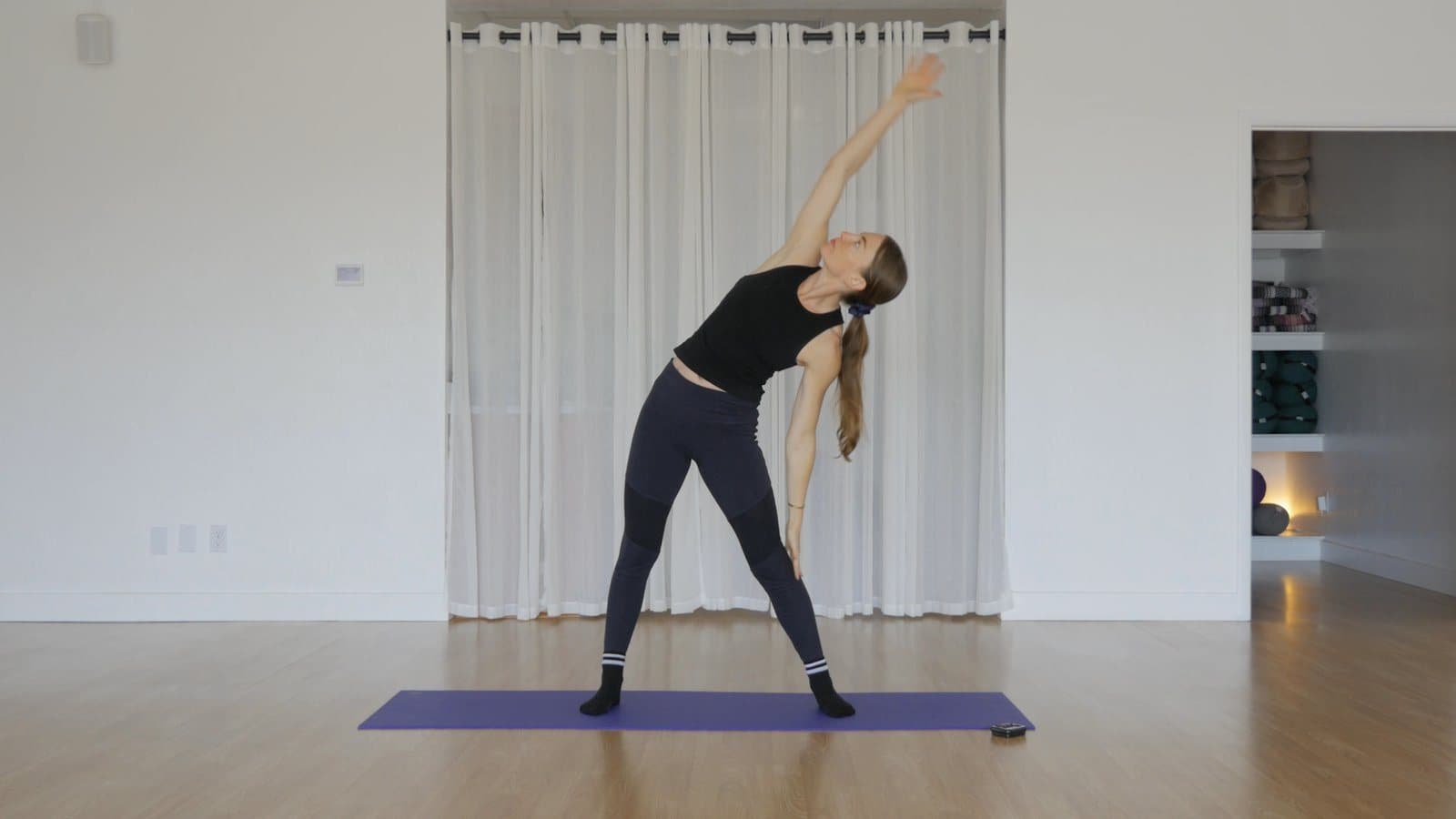 Standing side bend in a wide stance, one arm sweeping up and over the head